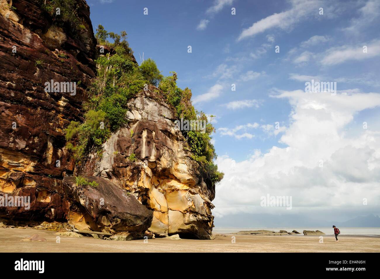 Malaysia, Borneo, Sarawak, Bako National Park, woman walking on Telok Assam beach near a cliff and rocks Stock Photo