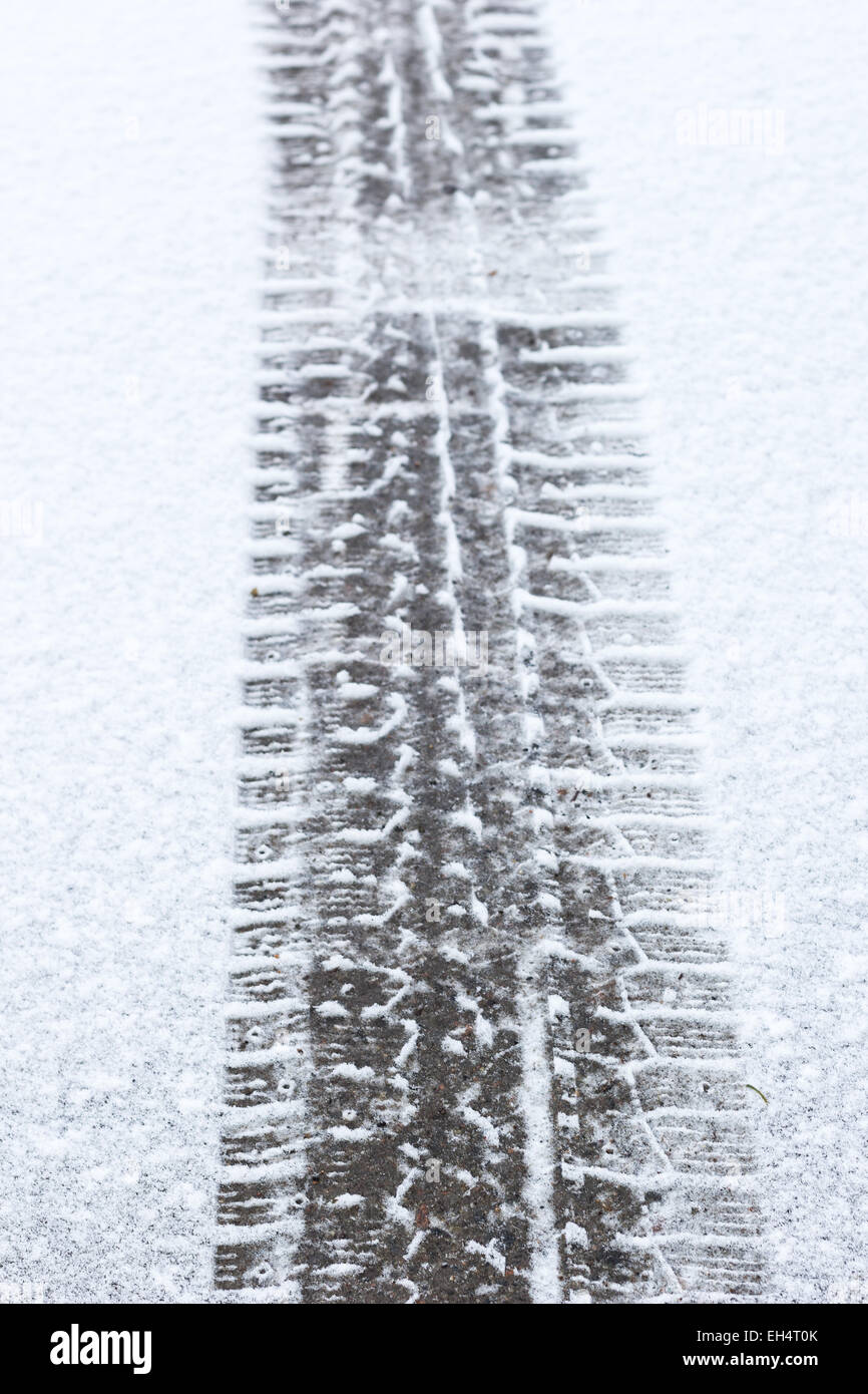 Closeup of car tire tracks on a snowy asphalt Stock Photo