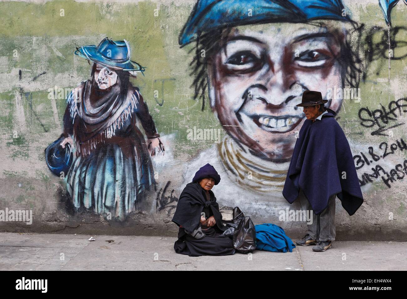 Ecuador, Imbabura, Otavalo, Ecuadorian man and beggar on the sidewalk on a background of graffiti wall, a market day Stock Photo