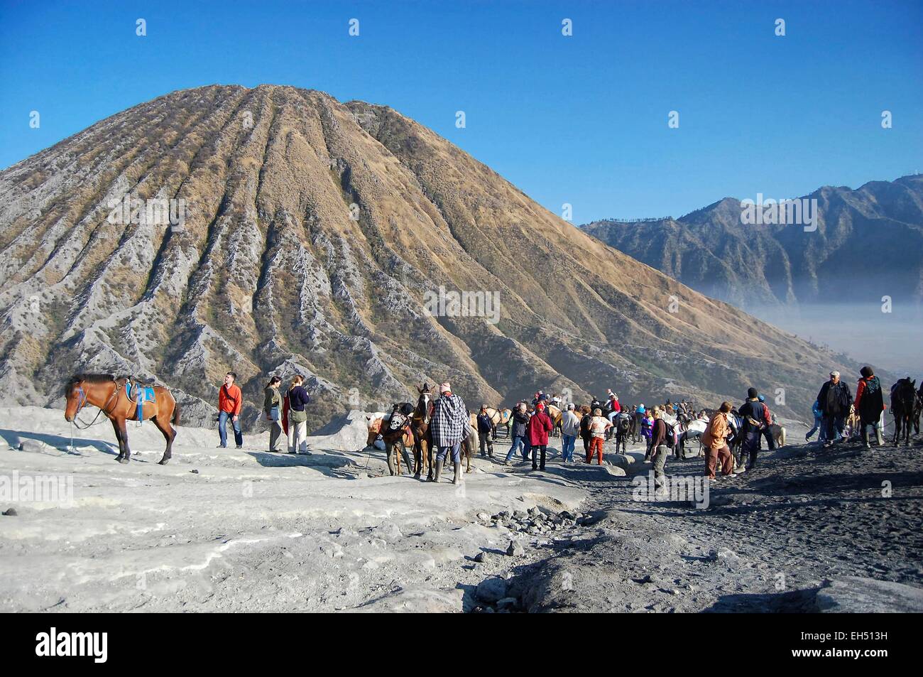 Indonesia, Java, Jawa Timur, Bromo-Tengger-Semeru National Park, tourists, locals and horses at the foot of mount Bromo, mount Batok in the background Stock Photo