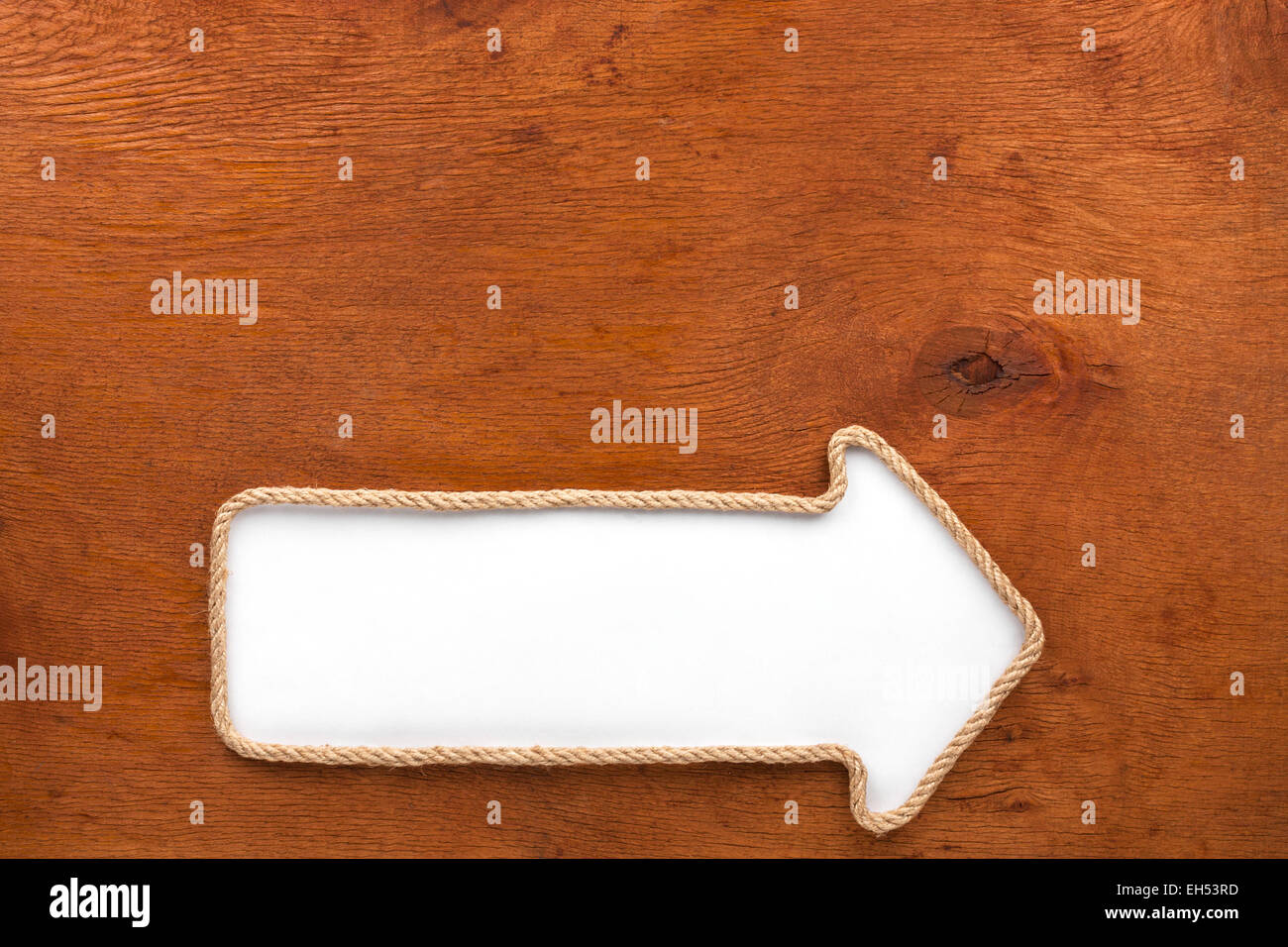 Pointer made of rope with a white background on the wood, with place ...