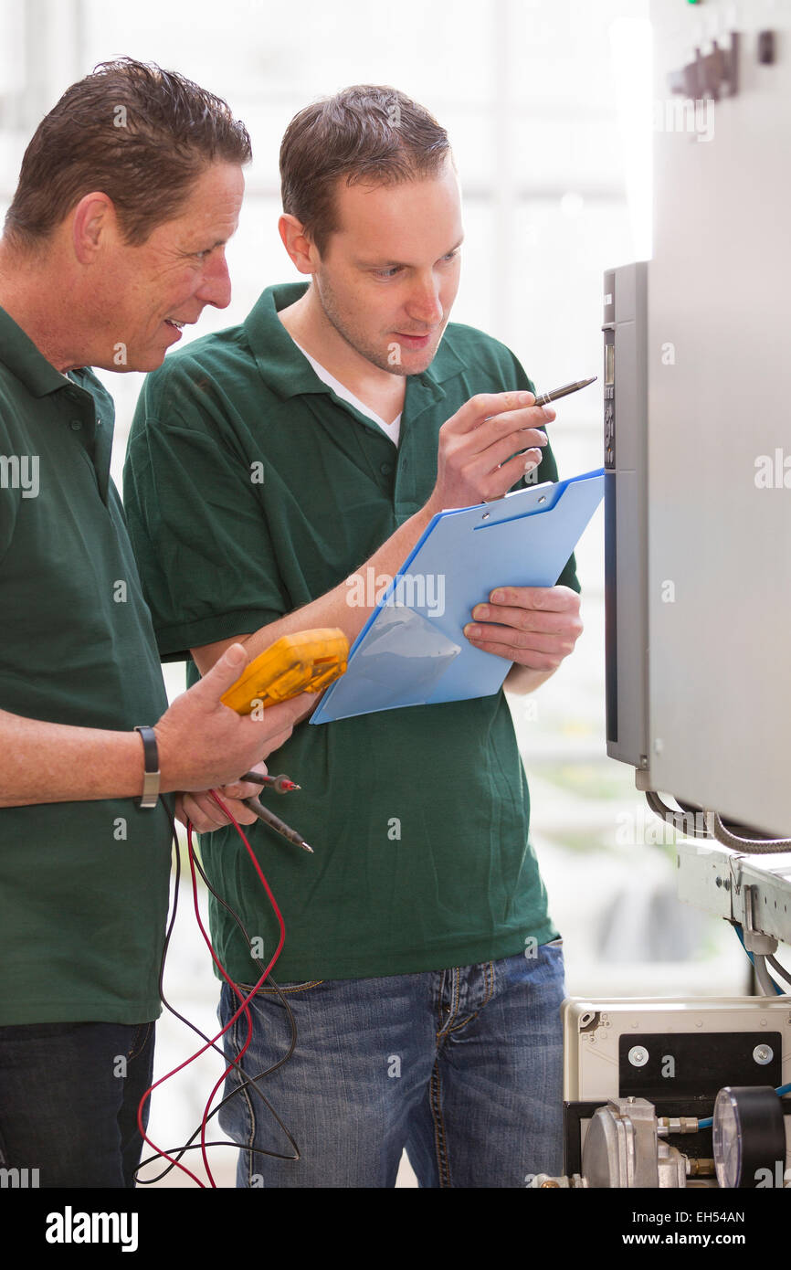 Senior technician and junior technician repairing agriculture machinery