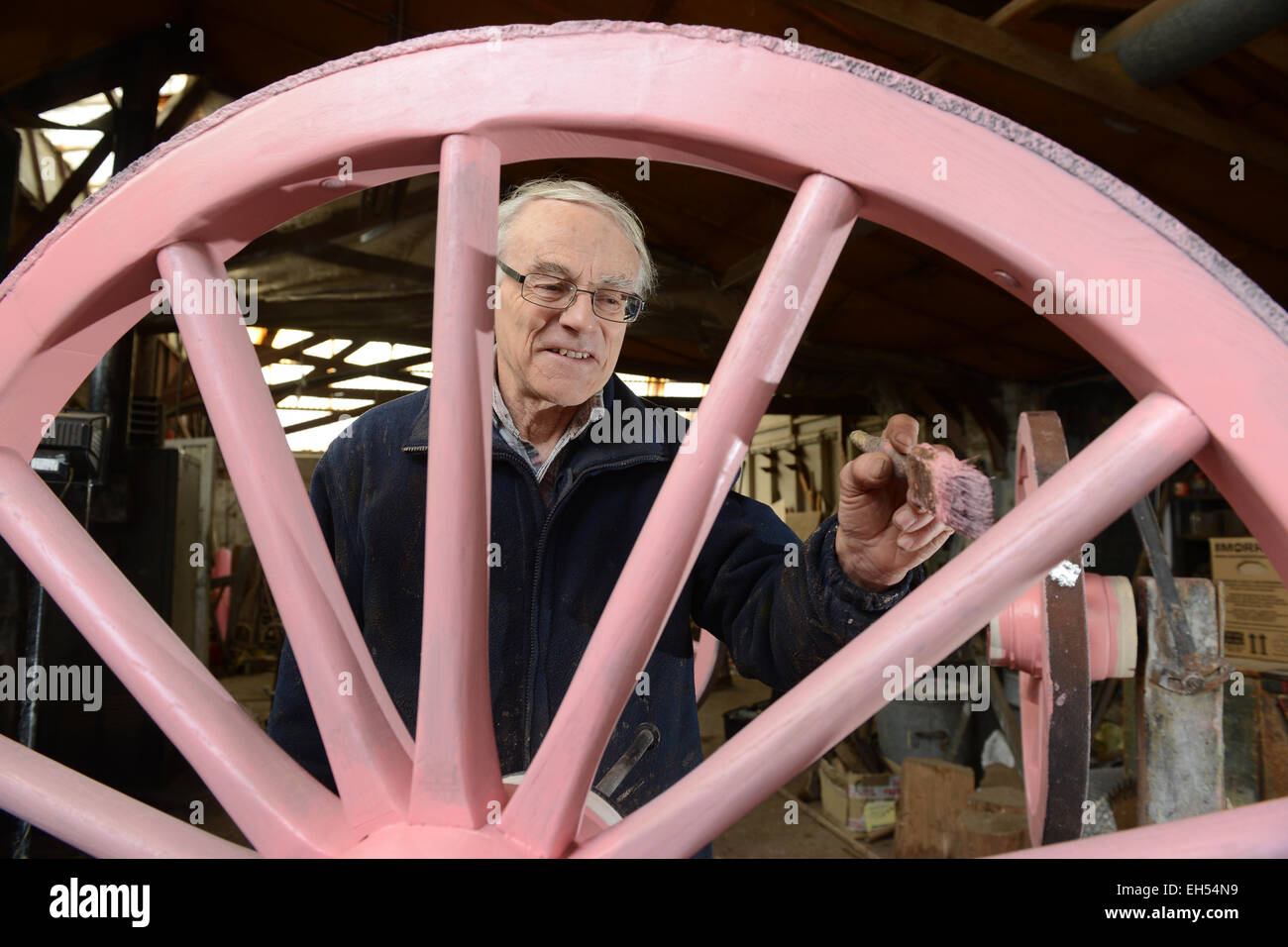 Wheelwright Phil Holder working on wooden spoked wheels at his workshop in Shropshire Stock Photo