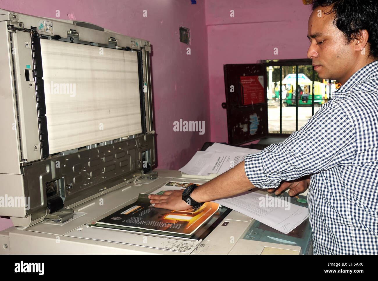 Indian man work on photocopy machine in office. Stock Photo