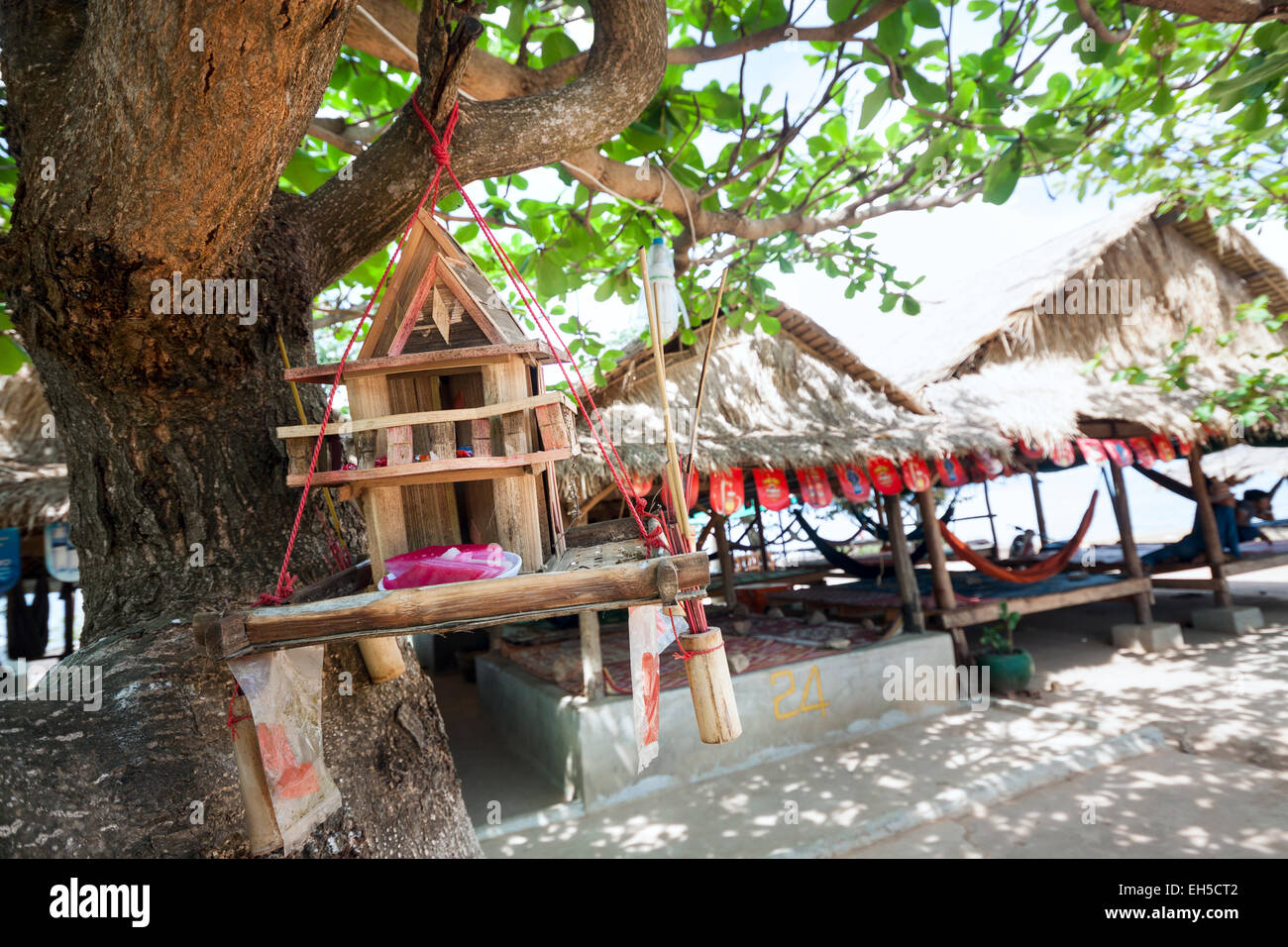 Kep, Cambodia - typical seaside restaurants and rest area and simple altar suspended from the tree nearby. Stock Photo
