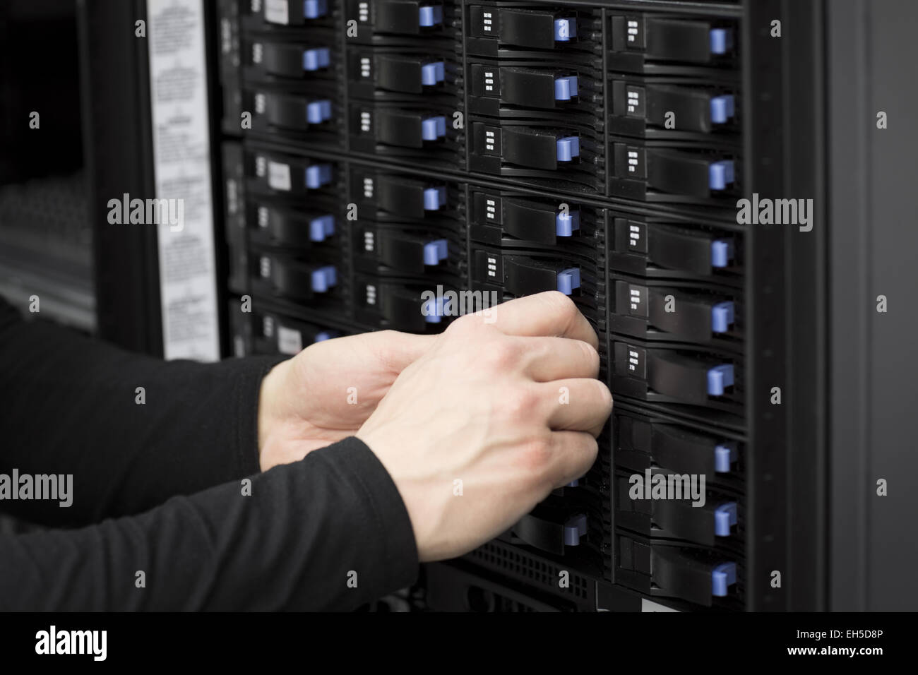 It engineer / technician working in a data center. Replace a hard drive in a SAN. Stock Photo