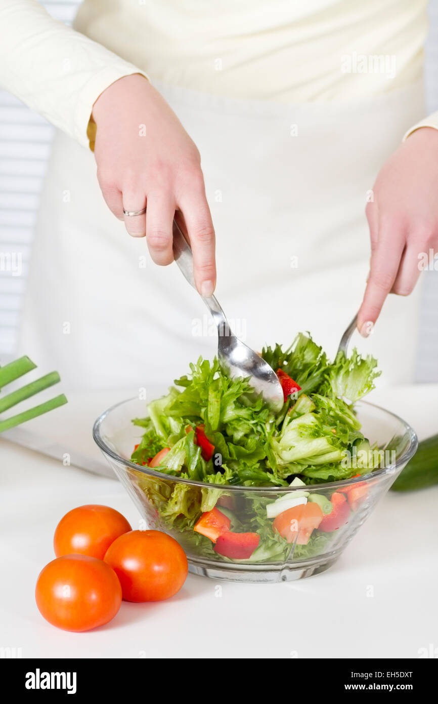 Making Salad Woman in a white kitchen making a healthy salad with vegetables Stock ...