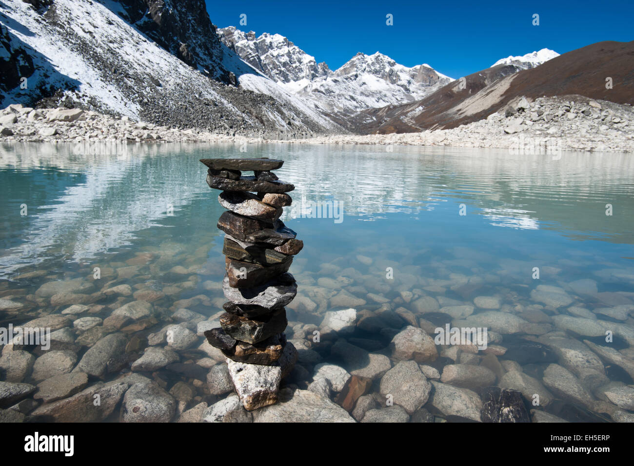 Harmony and balance: Stone stack and Sacred Lake near Gokyo. Travel to Nepal Stock Photo