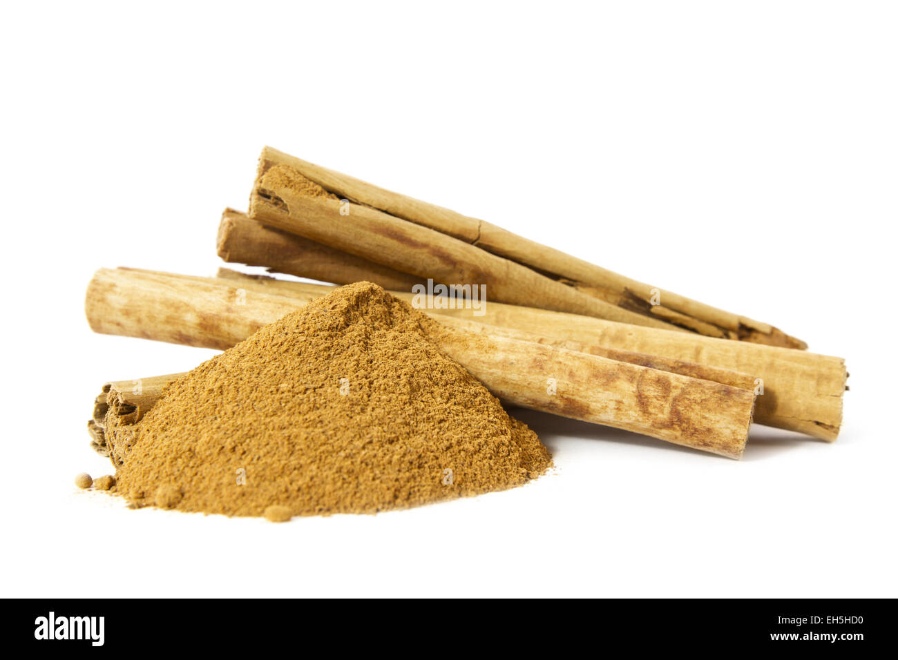Organic cinnamon sticks and cinnamon spice powder. Side view on white background. Stock Photo