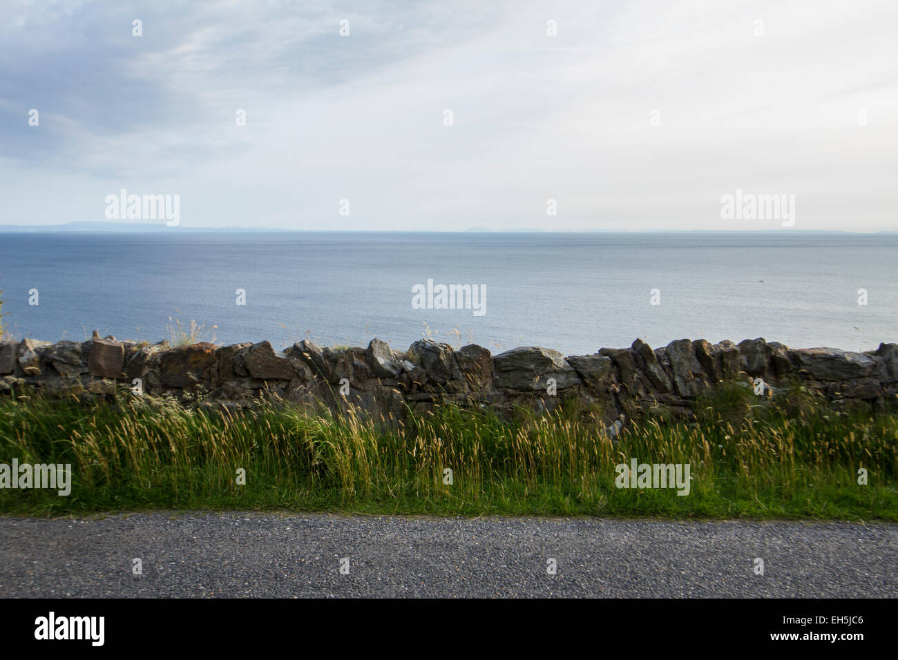 Abstract photograph of a stone wall with sea and sky behind, lots of copy space Stock Photo