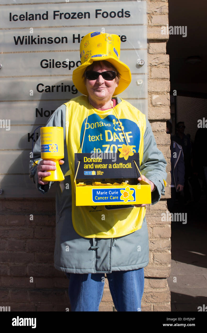 Woman selling daffodils for Marie Curie in Ely Cambridgeshire UK 7th