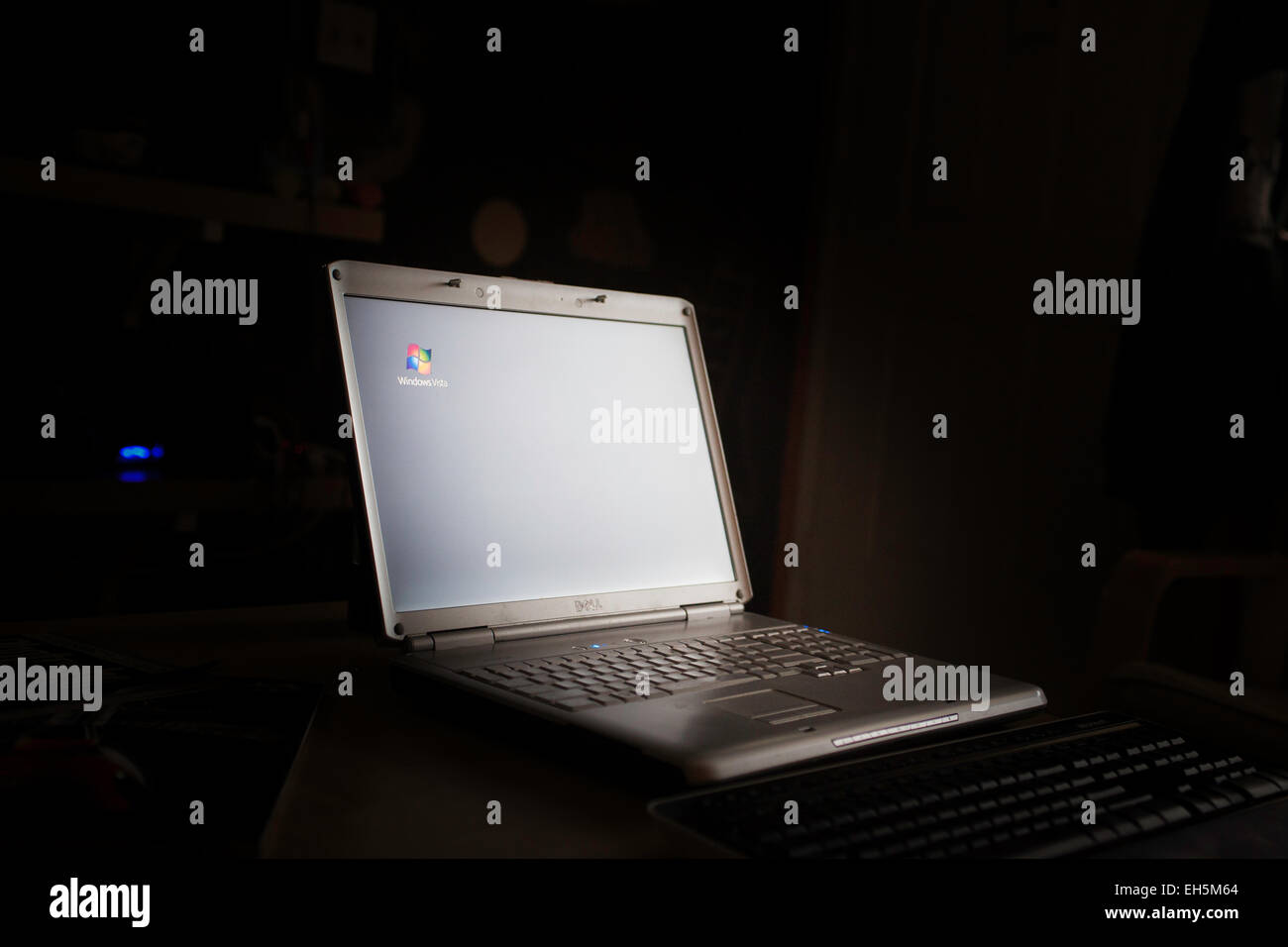 A Dell Laptop Computer in a darkened Room with Windows Vista screen saver active Stock Photo