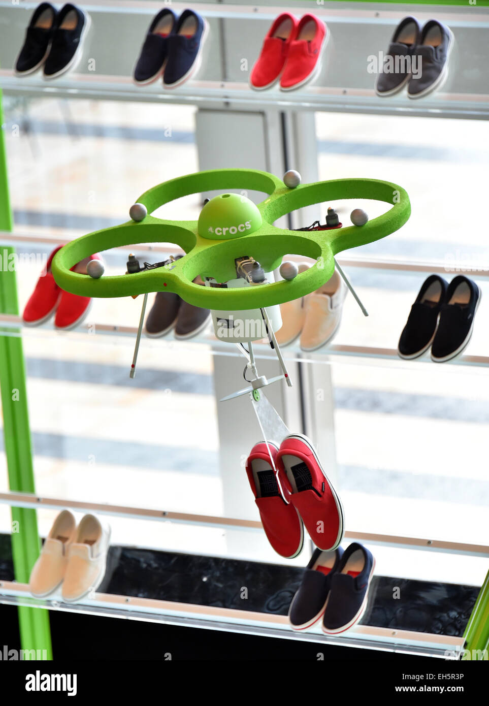 Tokyo, Japan. 7th Mar, 2015. A drone flies to the shelves and fetches a pair of tennis shoes to an awaiting customer at the 'flying shoe shop' in Tokyo on Saturday, March 7, 2015. As a customer uses an iPad to place an order, the drone takes off and delivers the requested pair from as many as 80 shoes displayed on a special stand, about 5 meters high and 10 meters wide. Credit:  Natsuki Sakai/AFLO/Alamy Live News Stock Photo