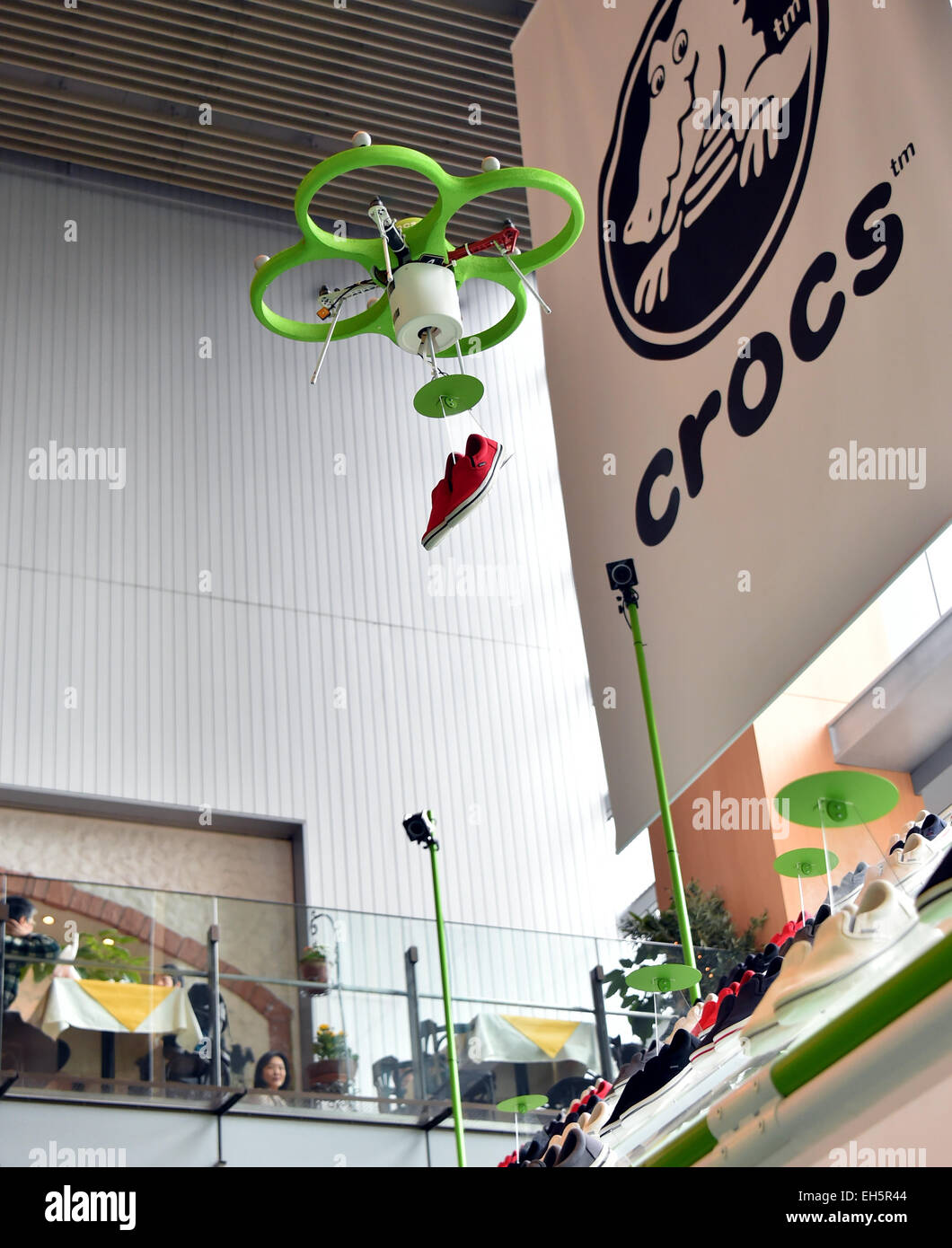 Tokyo, Japan. 7th Mar, 2015. A drone flies to the shelves and fetches a pair of tennis shoes to an awaiting customer at the 'flying shoe shop' in Tokyo on Saturday, March 7, 2015. As a customer uses an iPad to place an order, the drone takes off and delivers the requested pair from as many as 80 shoes displayed on a special stand, about 5 meters high and 10 meters wide. Credit:  Natsuki Sakai/AFLO/Alamy Live News Stock Photo