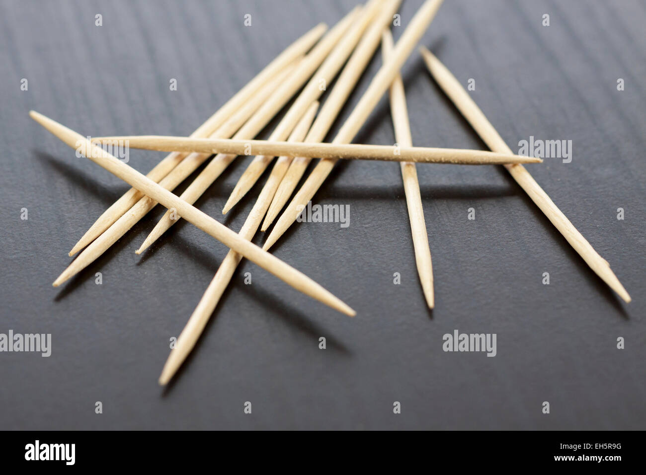 Pile of wooden toothpicks scattered randomly on a grey background for ...