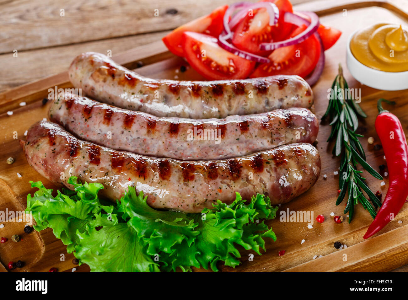 Grilled sausages with french fries on a cutting board Stock Photo