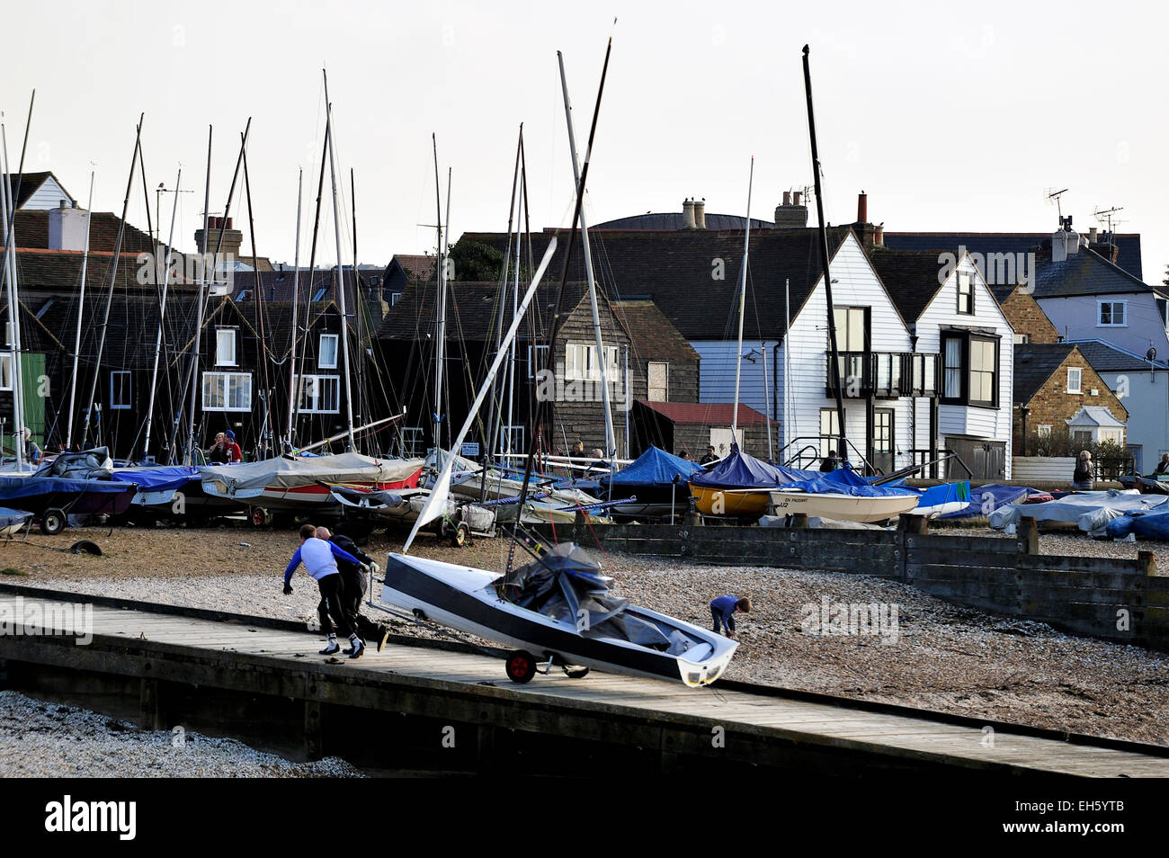 two people pulling a boat up the slipway whitstable kent Stock Photo