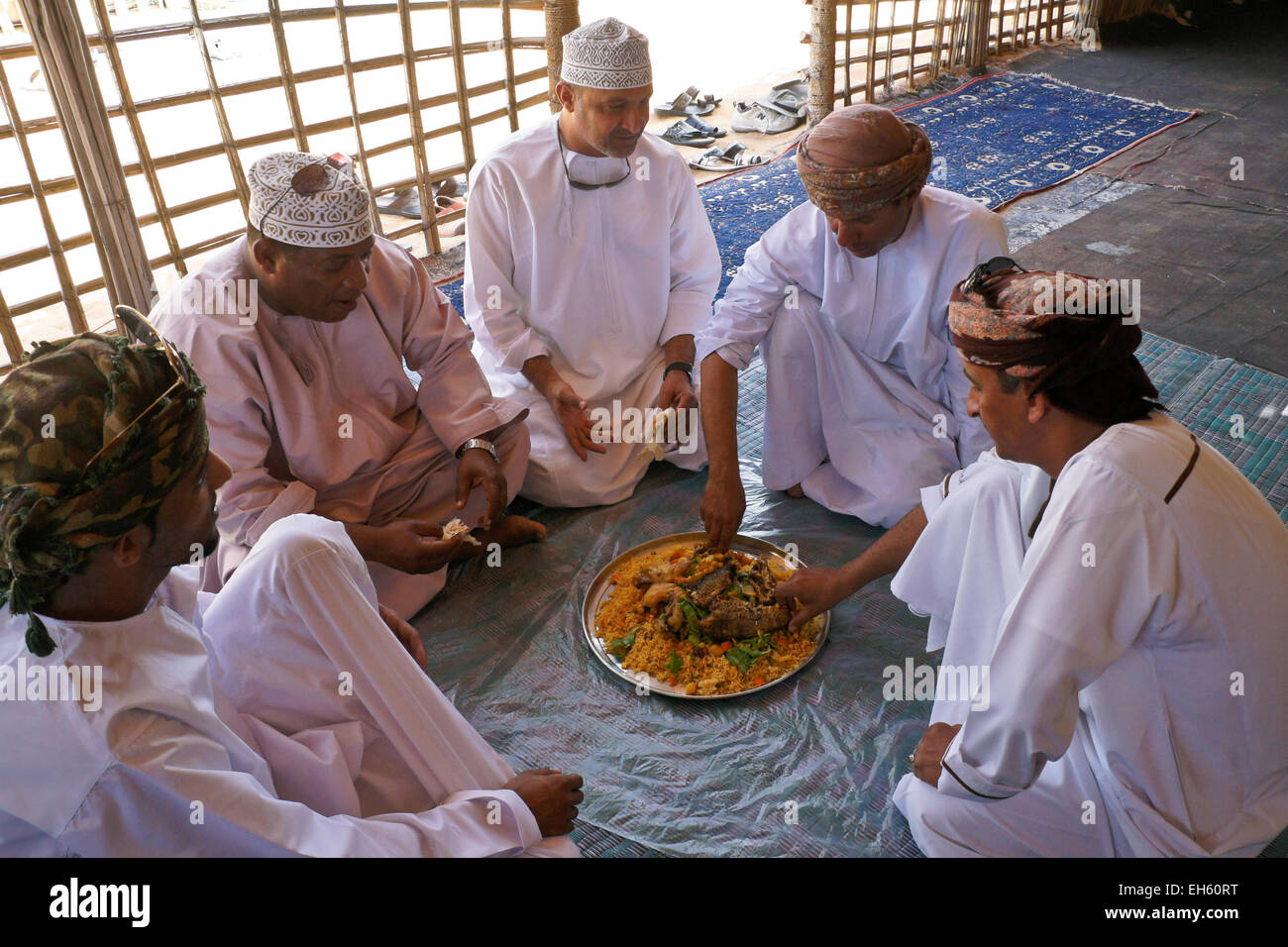Men sharing a meal in the traditional manner, Oman Stock Photo