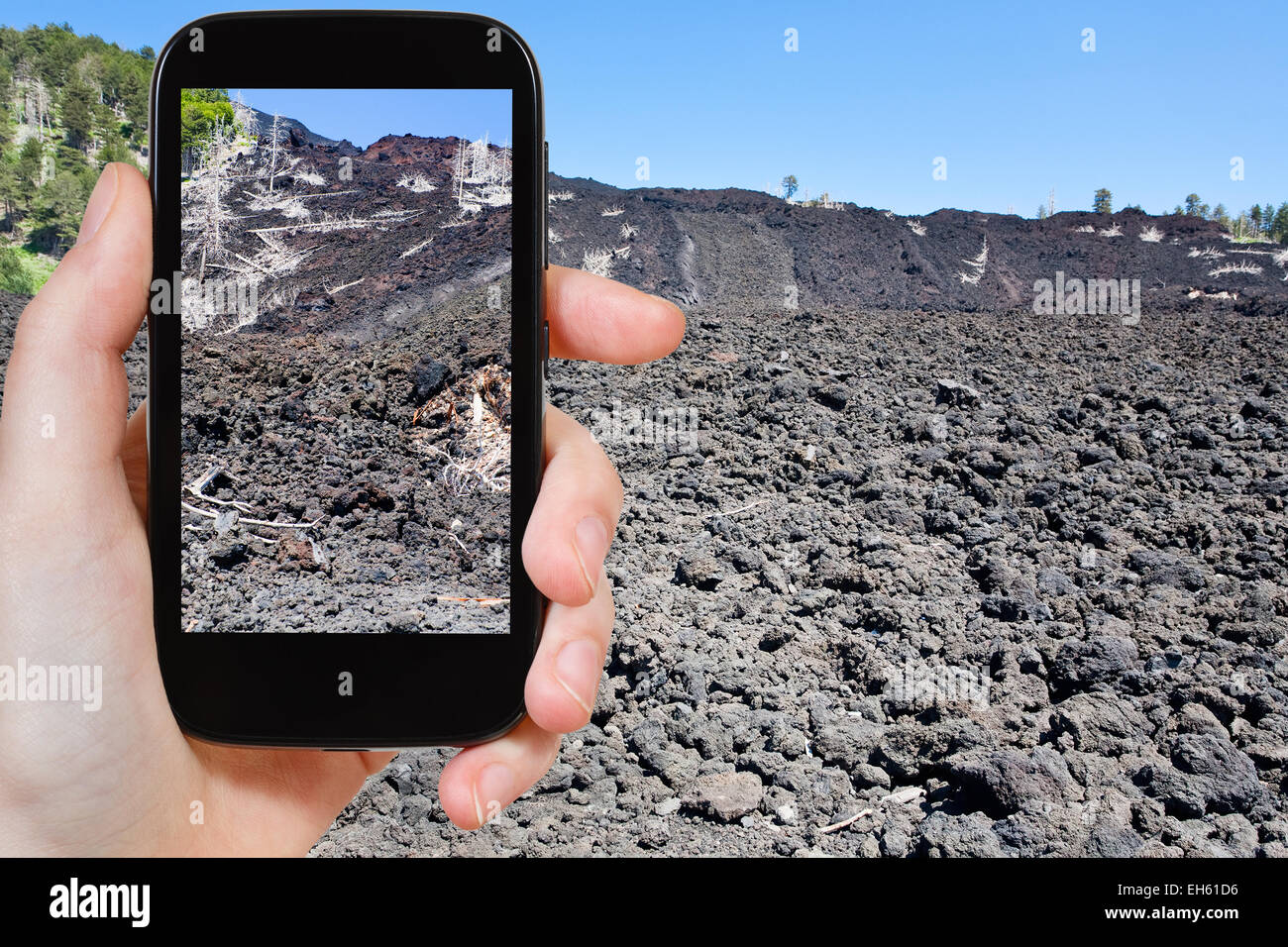 travel concept - tourist taking photo of hardened lava flow on slope of ...