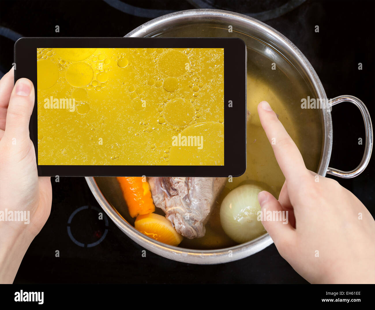 photographing food concept - tourist taking photo of boiling beef broth with with seasoning vegetables on mobile gadget Stock Photo