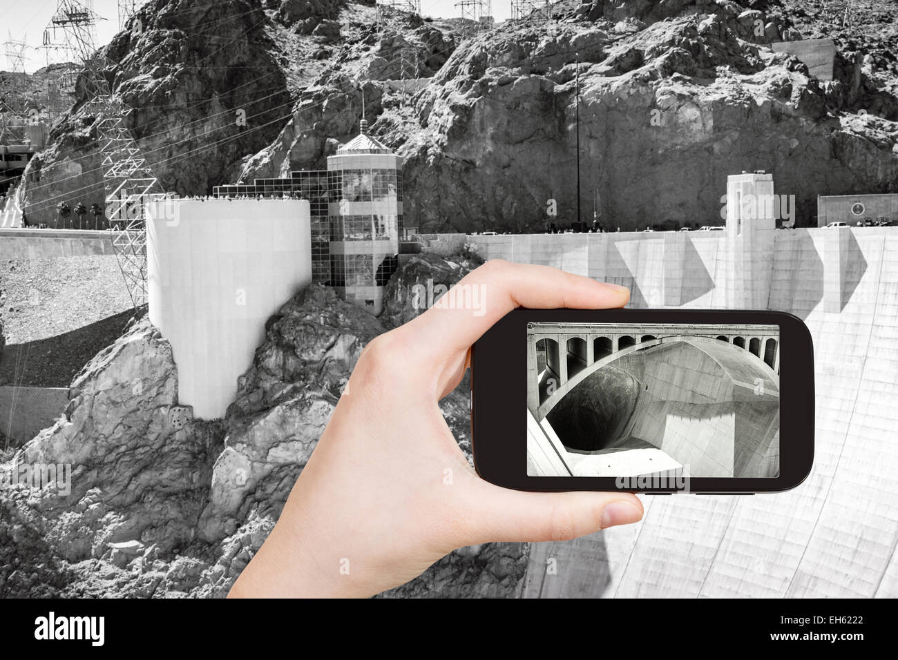 travel concept - tourist shooting photo of Hoover Dam on mobile gadget, USA Stock Photo