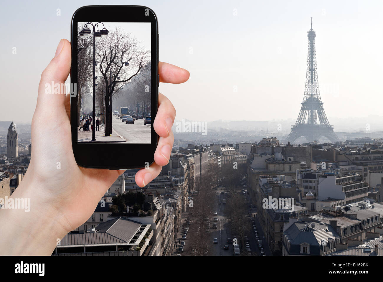 travel concept - tourist taking photo of Avenues in Paris in early spring on mobile gadget, France Stock Photo