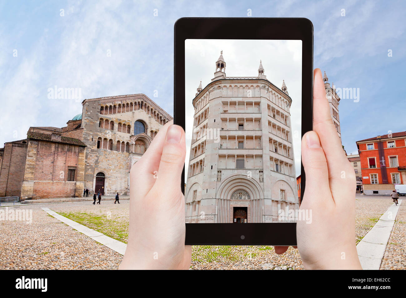 travel concept - tourist taking photo of Baptistery on Piazza del Duomo, Parma, Italy on mobile gadget Stock Photo