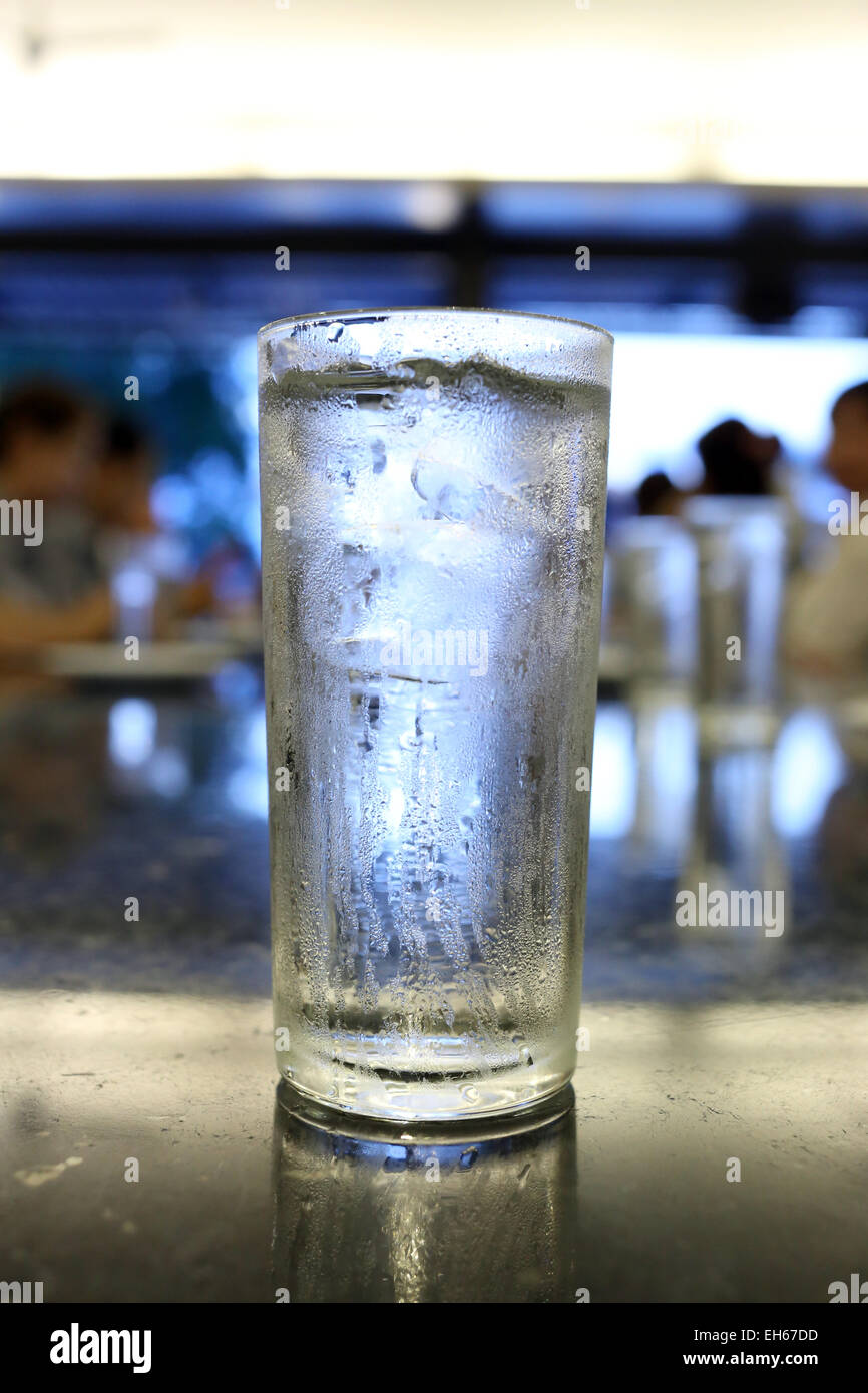 Drinking water in glass on tableware. Stock Photo