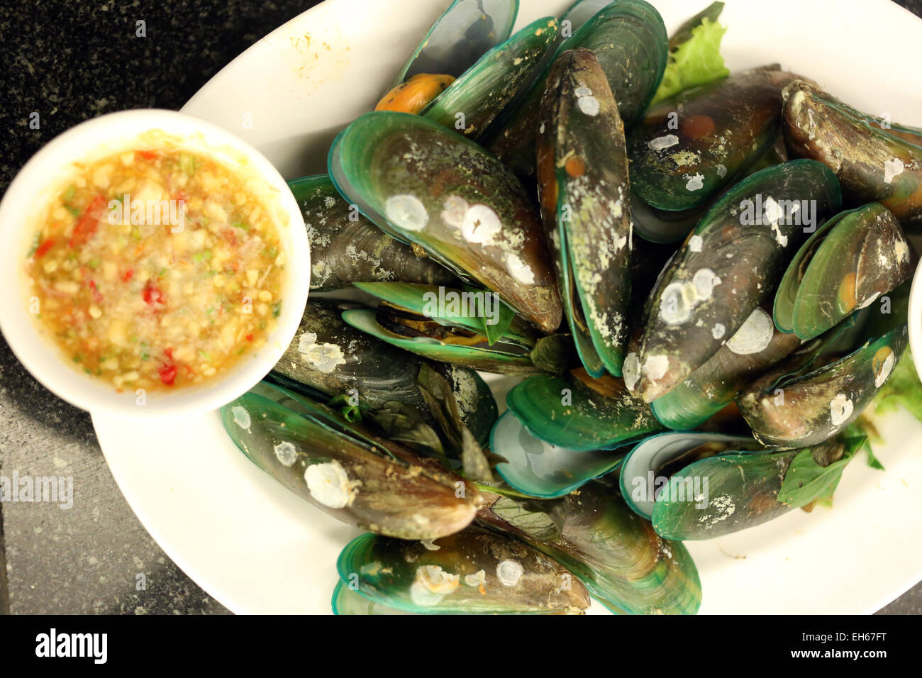 Boiled mussels on white dish in a restaurant. Stock Photo