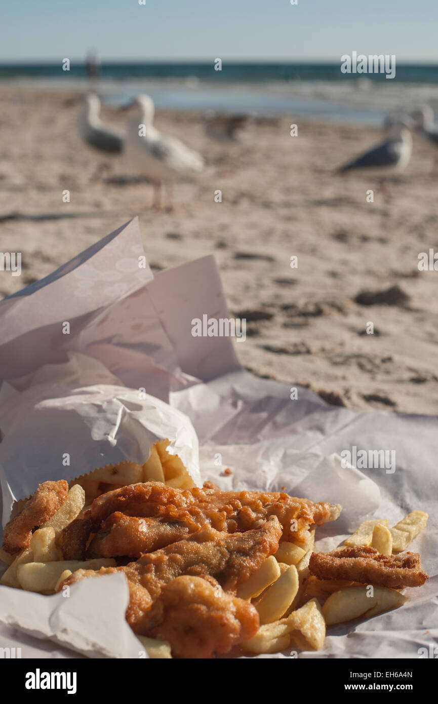 Fish and Chips on the beach in Adelaide, South Australia, with seagulls and the ocean in the background. Stock Photo