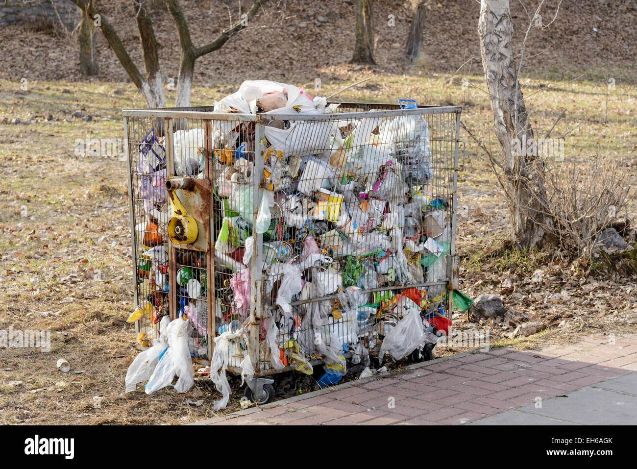 https://c8.alamy.com/comp/EH6AGK/metallic-garbage-container-full-of-trash-outdoor-in-the-country-EH6AGK.jpg