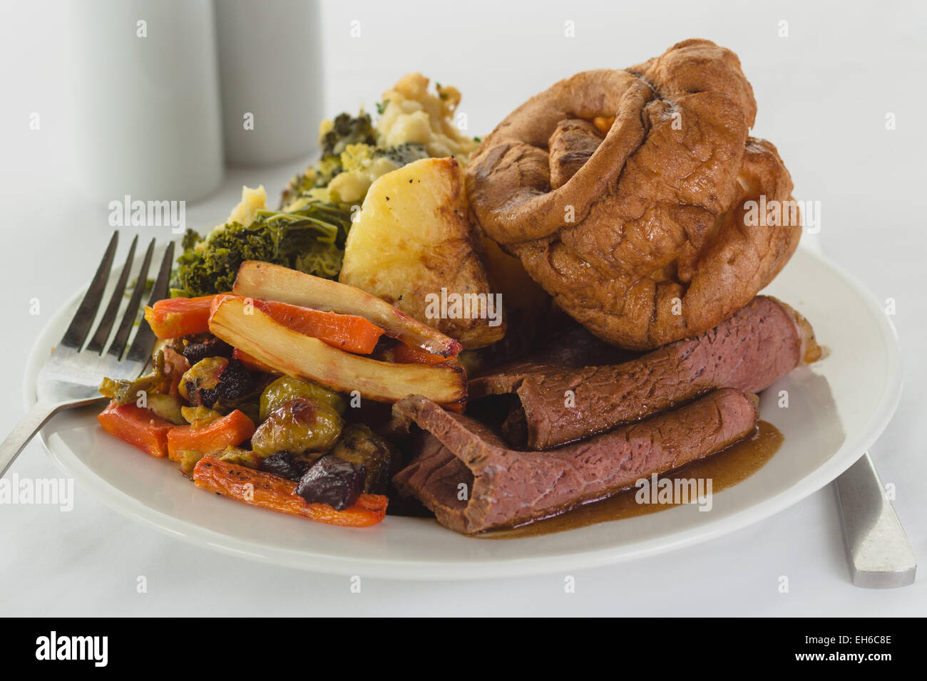 Plated Beef roast dinner with knife and fork on light background Stock Photo