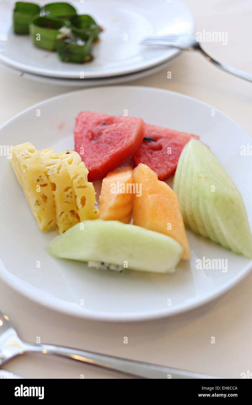 Mixed fruits in white dish on the foods table. Stock Photo