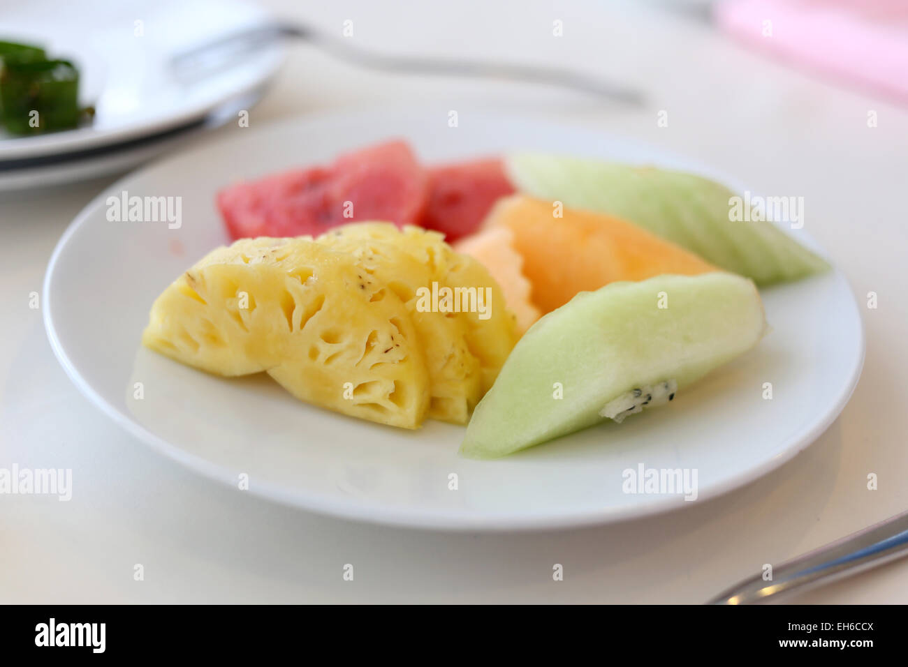 Mixed fruits in white dish on the foods table. Stock Photo
