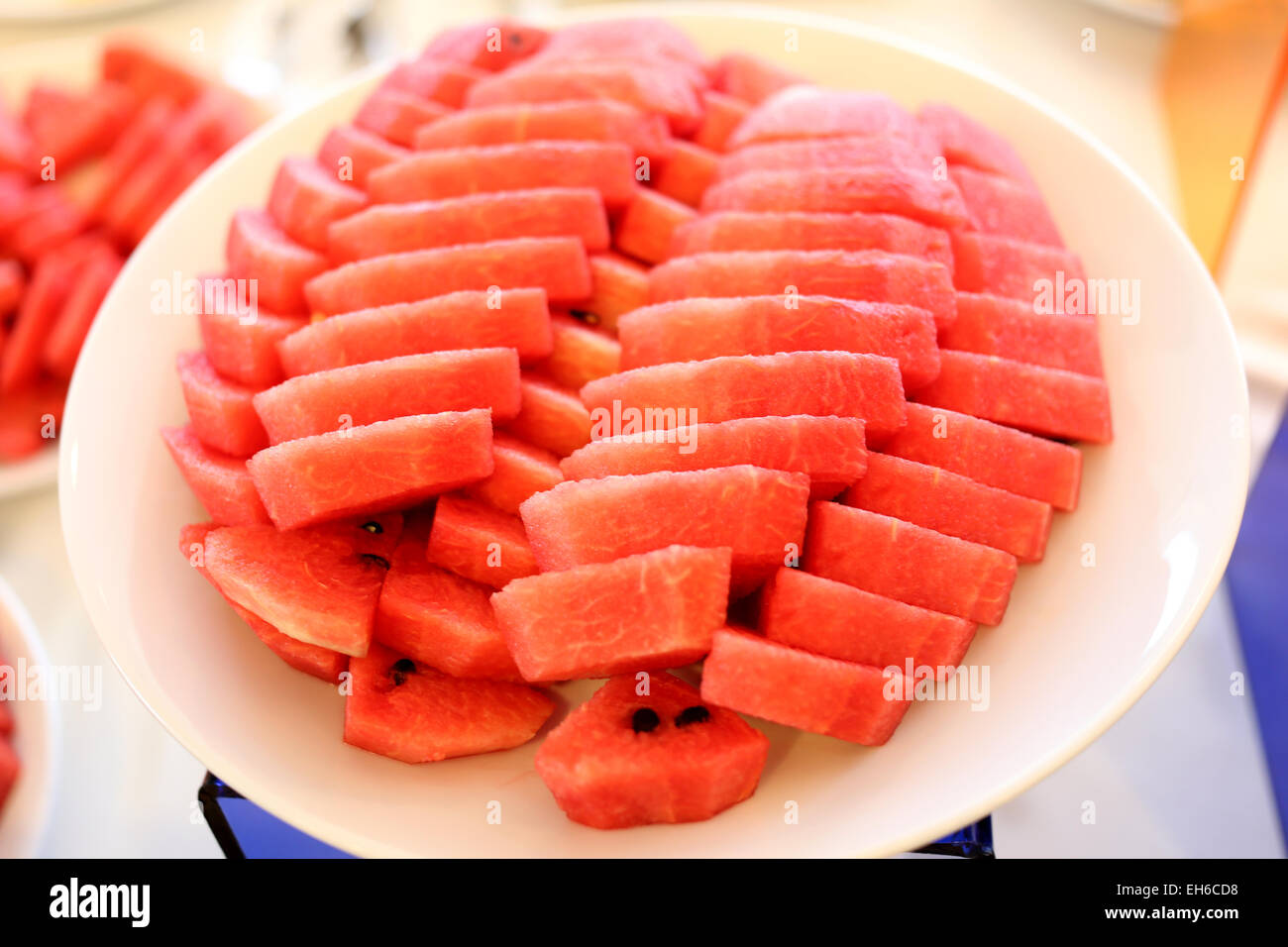 Watermelon cut in pieces in white dish on the foods table. Stock Photo