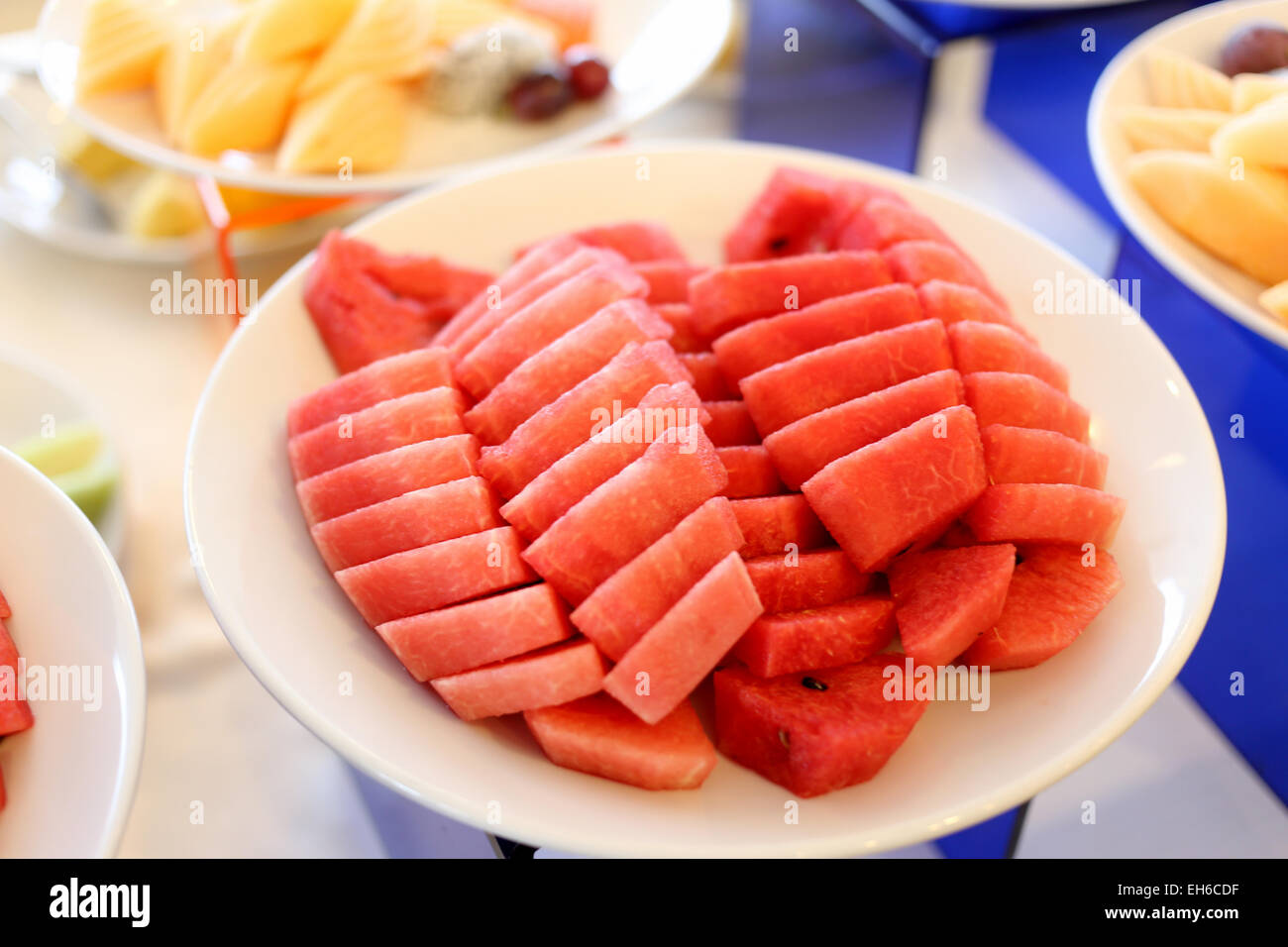 Watermelon cut in pieces in white dish on the foods table. Stock Photo