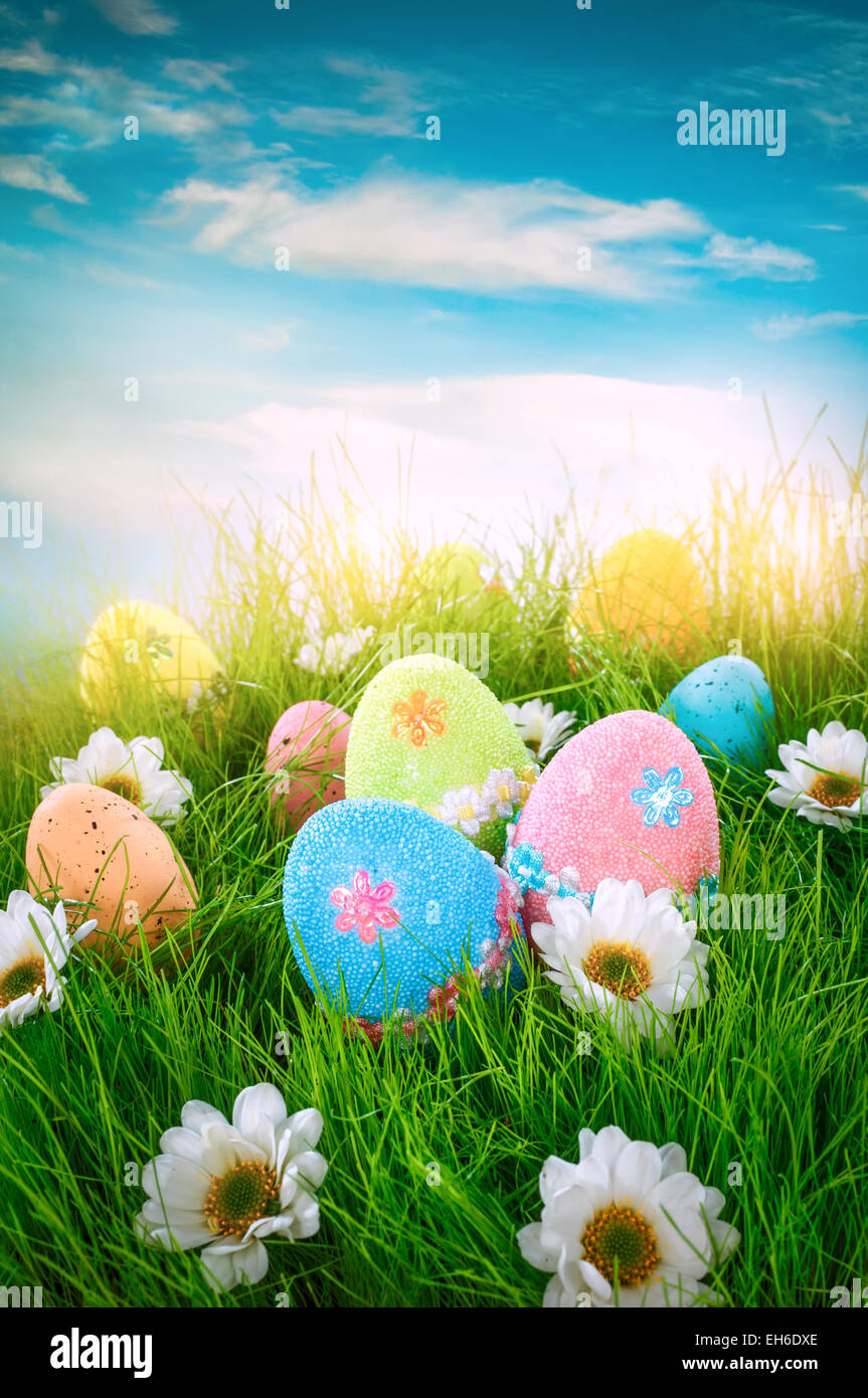 Decorated easter eggs in the grass on blue sky background Stock Photo ...