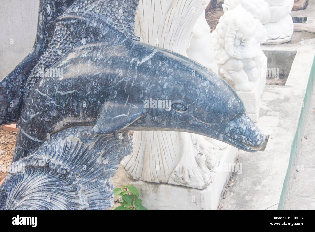 A blue dolphin statue, between other statues in vietnam Stock Photo Alamy