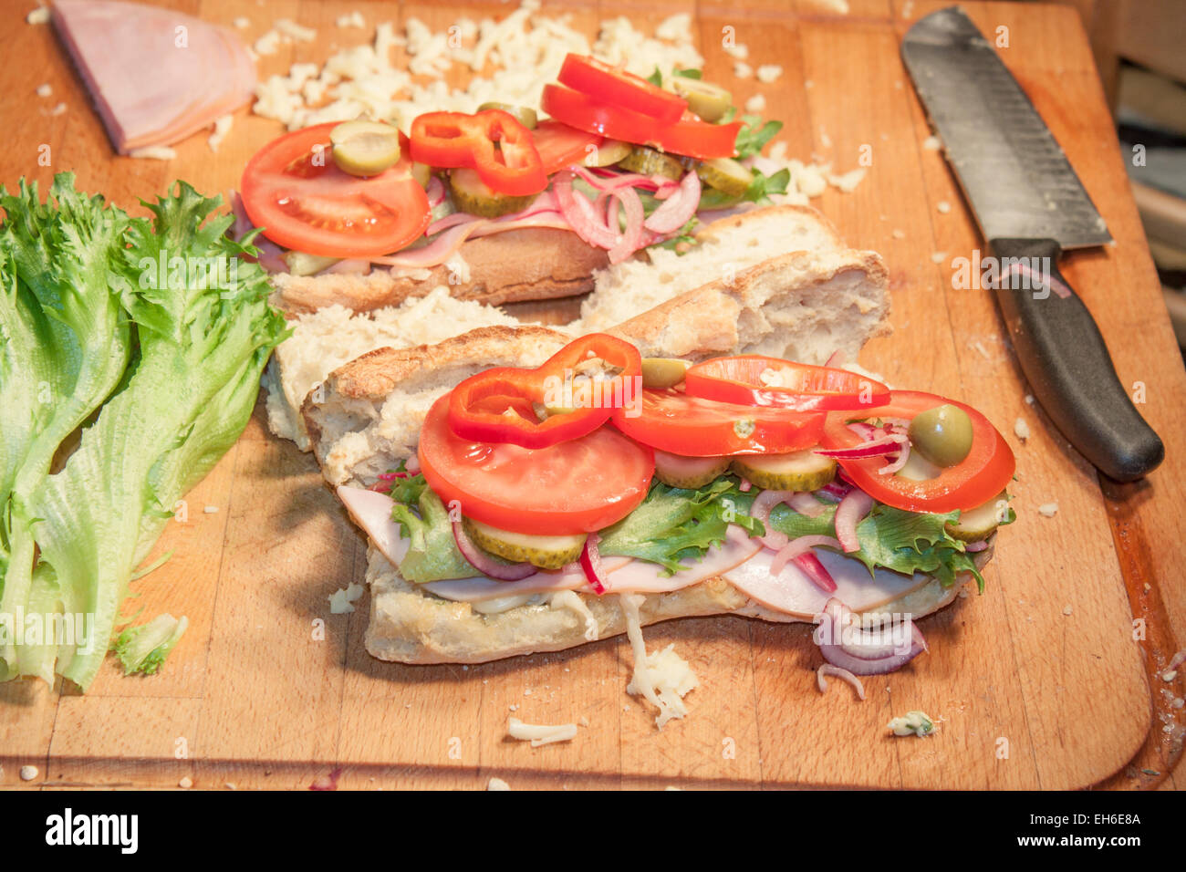 French bread sandwich, filled with ham, salad, red onion and tomato Stock Photo