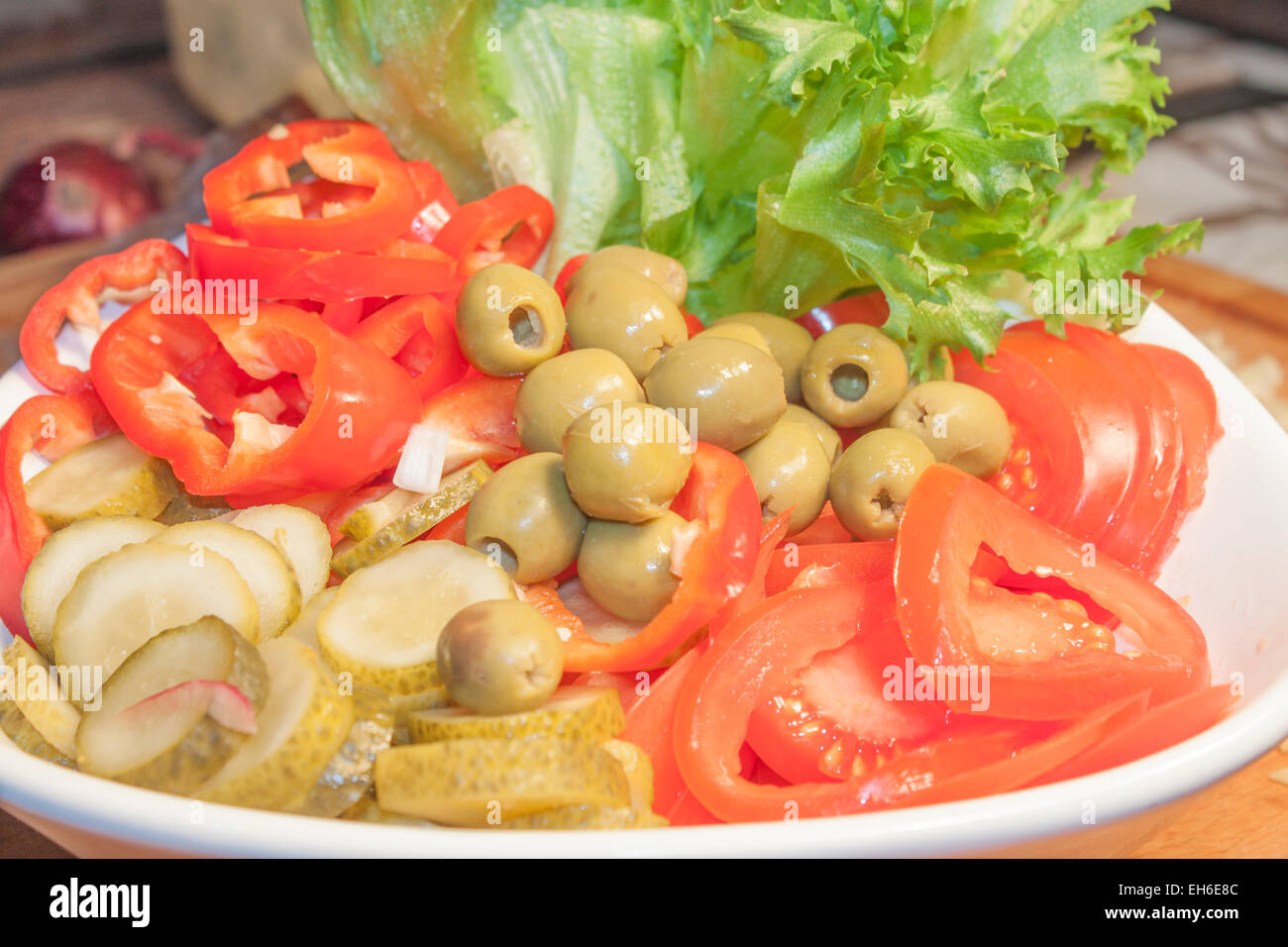 Green olives, between pepper, pickle, salad and tomatoes Stock Photo