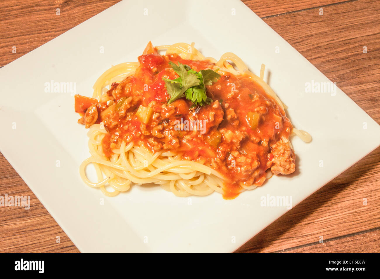 Spagett bolognaise and few coriander leafs, on a white plate Stock Photo