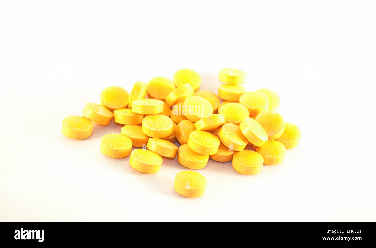 A lot of yellow B-vitamin supplement pills, on white background Stock Photo