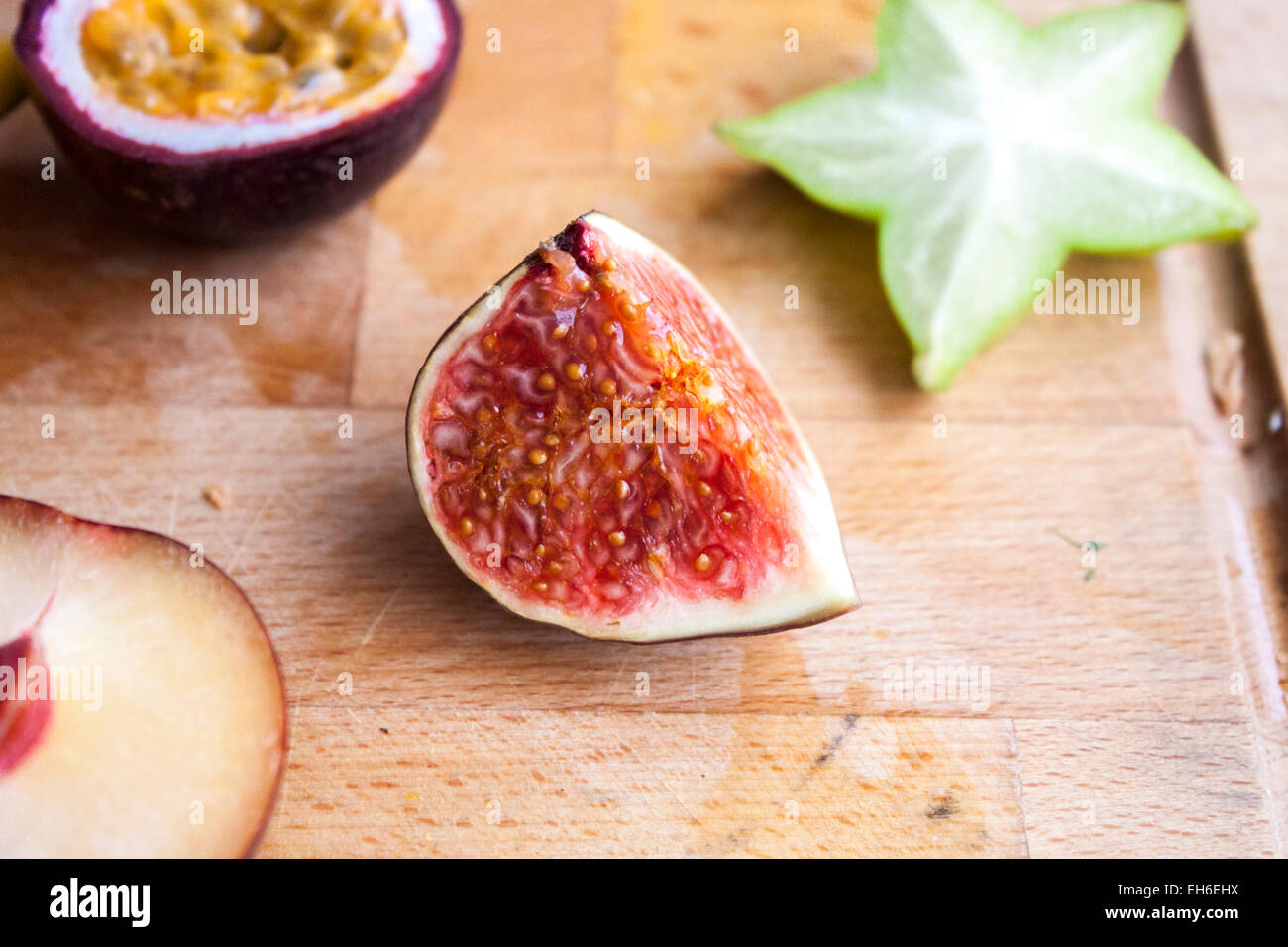 Fig, near plum, carambola and passion fruit, on a wooden cutting board Stock Photo