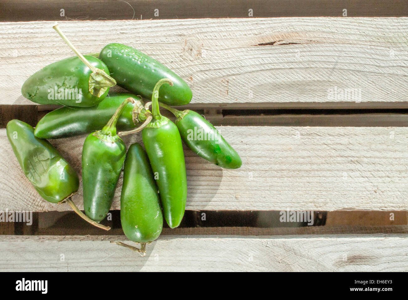 A lot of green jalapenos, on a wooden background Stock Photo