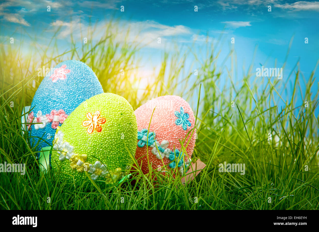 Decorated easter eggs in the grass on blue sky background Stock Photo ...