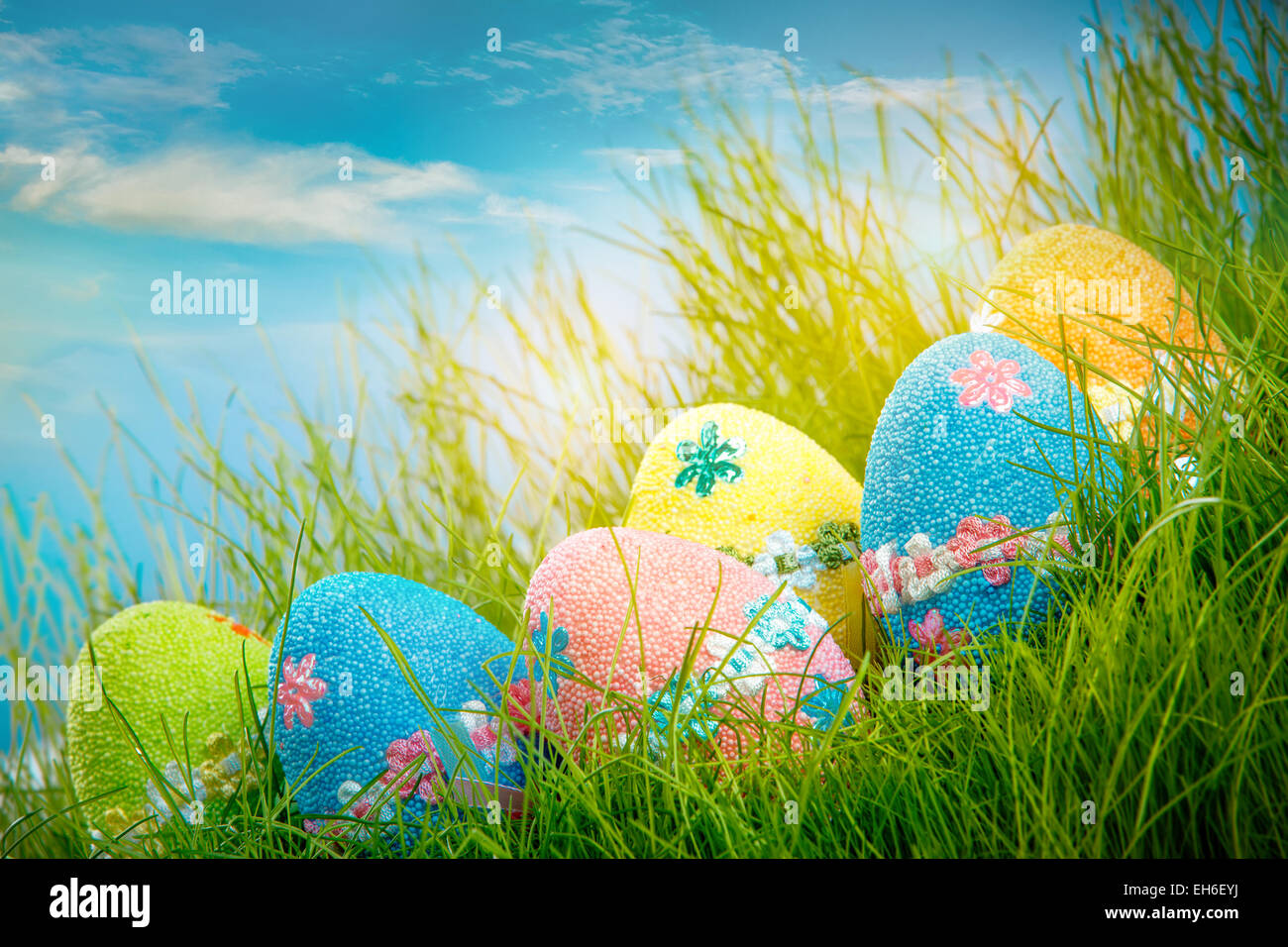 Decorated easter eggs in the grass on blue sky background Stock Photo ...