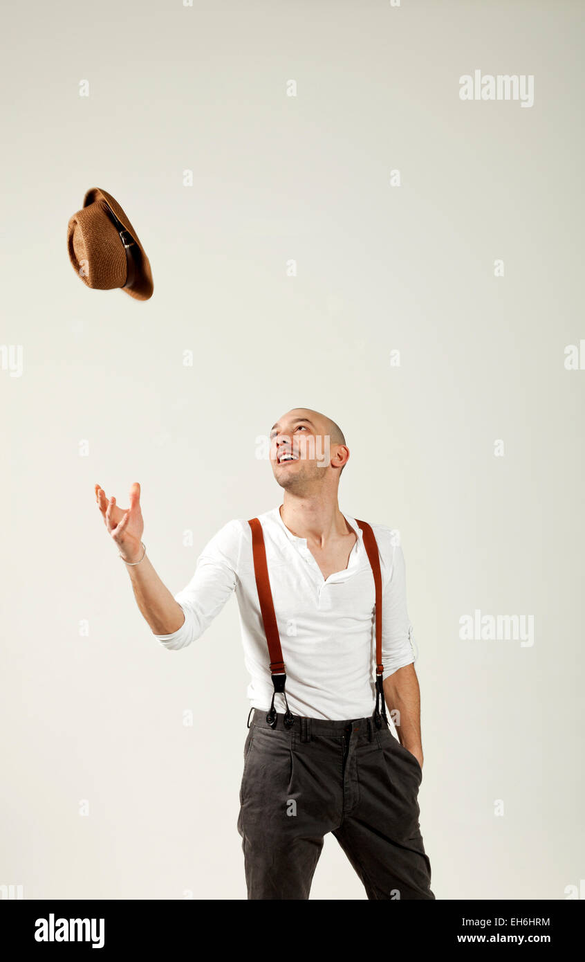man throws his hat in air, portrait in studio Stock Photo Alamy