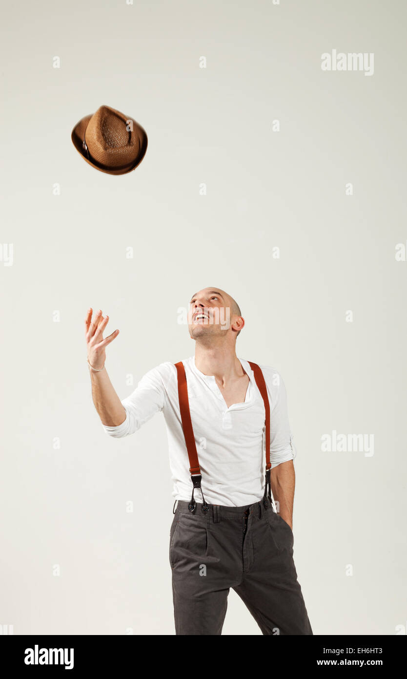 man throws his hat in air, portrait in studio Stock Photo Alamy