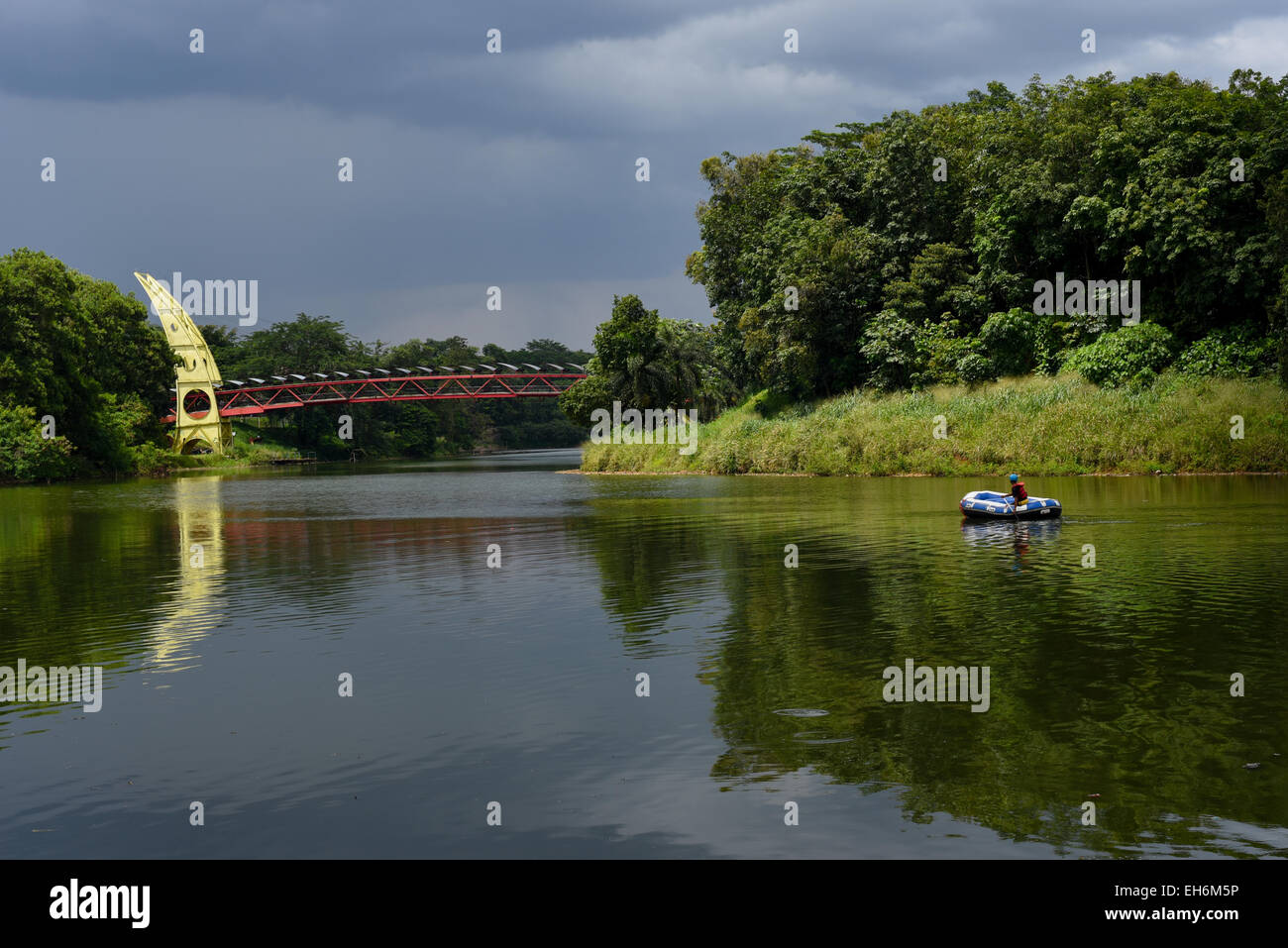 Man rows inflatable raft toward a gate at the campus of University of Indonesia in Depok, West Java. Stock Photo