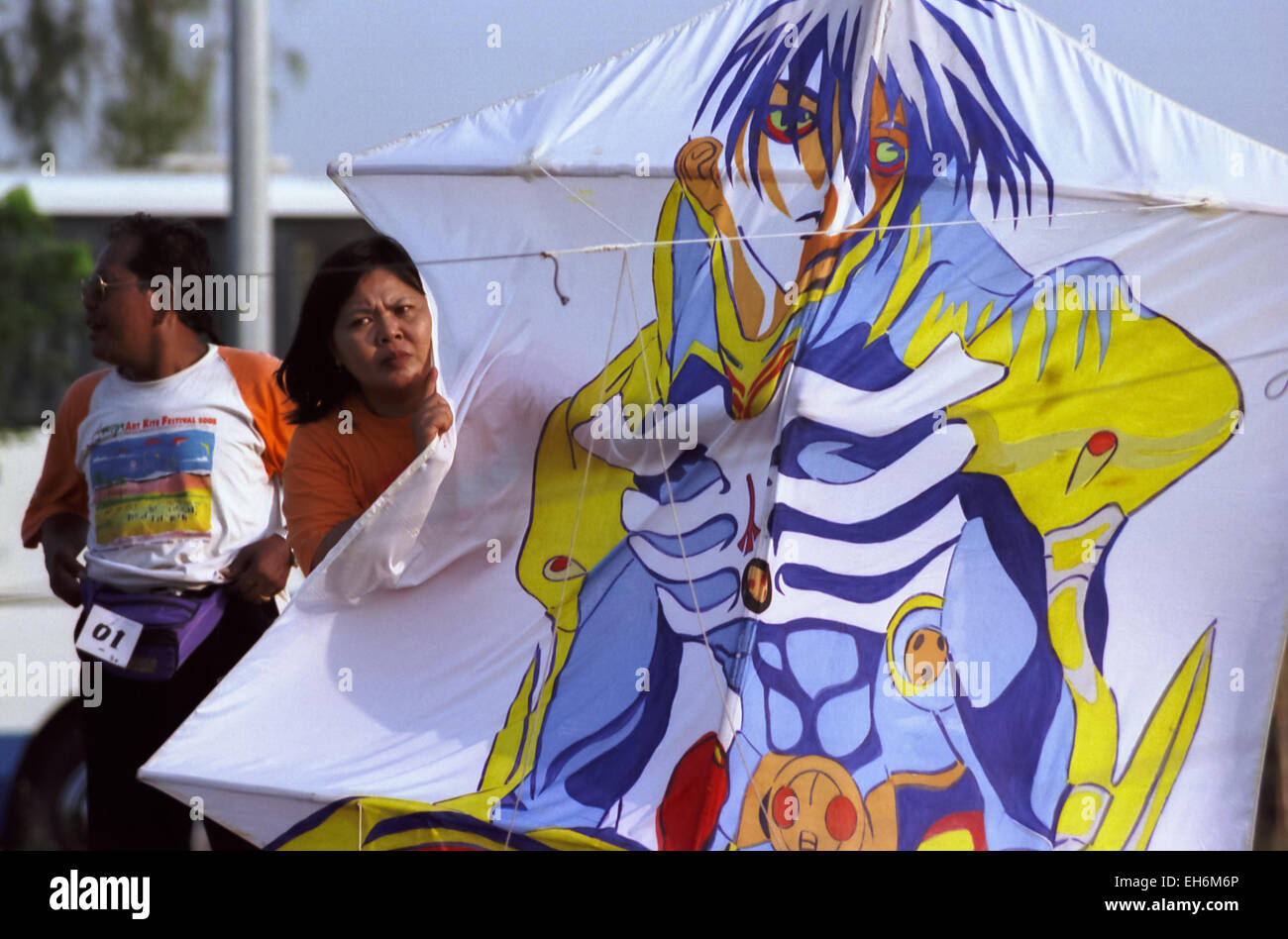 Woman preparing a kite decorated with Japanese comic character for the Jakarta International Kite Festival in Jakarta, July 09-11, 2004. Stock Photo